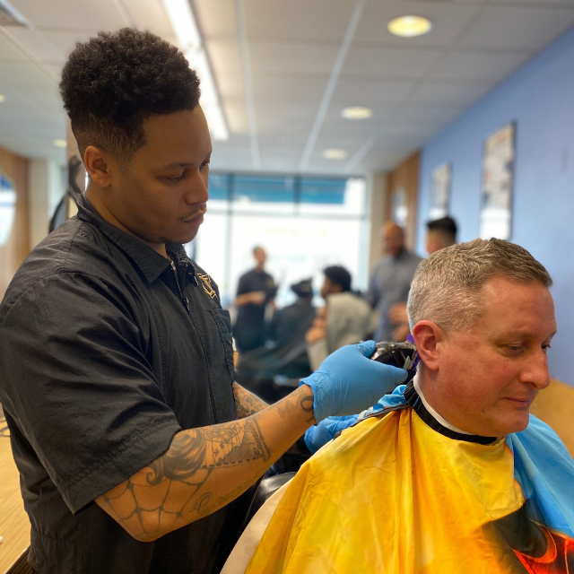 A student at Champions Barbering Institute Cuts Hair