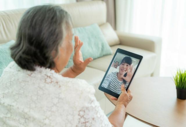 Elderly woman uses tablet to video chat