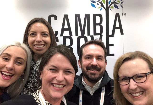 A group of people standing in front of the Cambia Grove logo