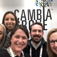 A group of people standing in front of the Cambia Grove logo
